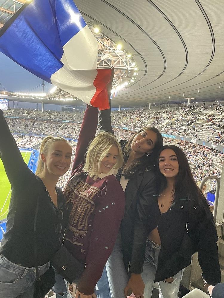 4名学生在法国足球场上挥舞着法国国旗
